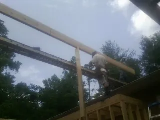 Carpenter setting a ridge beam over a new addition frame — Ice Dam Removal by Roofing Brothers in Schoenchen